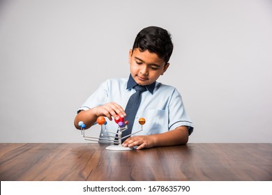 Indian School Kid / Boy Studying Planets Or Planetary Science With 3d Model Of Our Solar System