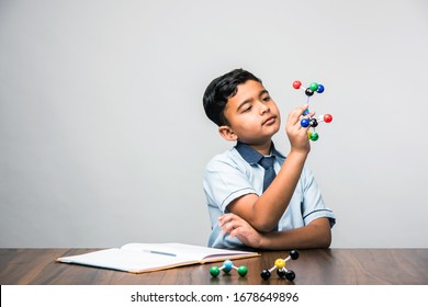 Indian school kid or science student Using Molecular Model Kit for studying physics, selective focus - Powered by Shutterstock