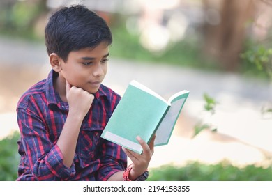 Indian Schoolboy Reading A Book In The Garden	
