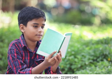 Indian Schoolboy Reading A Book In The Garden	
