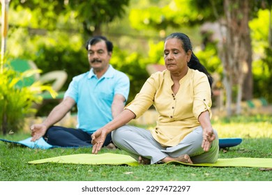 Indian senior couple doing meditation or yoga at park - concept of healthy lifestyle, mental wellness and self acre. - Powered by Shutterstock