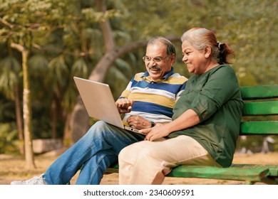 indian senior couple sitting at park and using laptop - Powered by Shutterstock