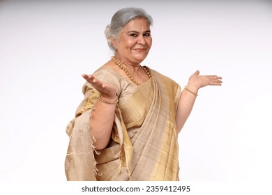 Indian Senior happy women open hands with big smiling while standing isolated in over grey background. - Powered by Shutterstock