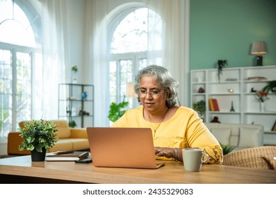 Indian senior lady using laptop, computer at home office - Powered by Shutterstock