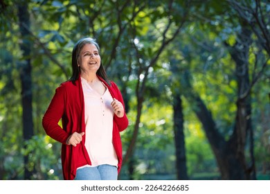 Indian senior woman doing exercise or jogging at park. - Powered by Shutterstock