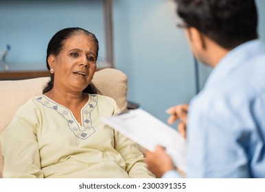 Indian senior woman explaining problems to psychologist during counselling at home - concept of home appointment, troube assessment and mental illness - Shutterstock ID 2300391355