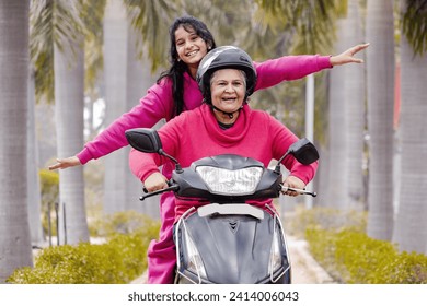 Indian Senior woman with Grand daughter Driving Scooter moped Enjoying Life ,Insurance Concept - Powered by Shutterstock