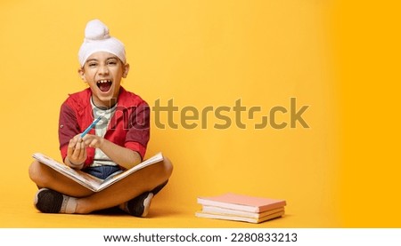 Indian Sikh kid sitting on floor with books and shouting   Stock fotó © 