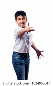 Indian small kid posing as if throwing or playing Frisbee or boom rang, standing isolated against white background