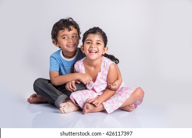 indian small siblings hugging, portrait of 2 indian kids, Indian small boy and small girl sitting close together over white background, cheerful indian boy and girl posing for a photo