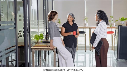 Indian smiling old business women standing hold cup drink coffee talk gossip indoor work place. Beautiful young adult corporate girls make funny blab share ideas during tea break spend time job office - Powered by Shutterstock