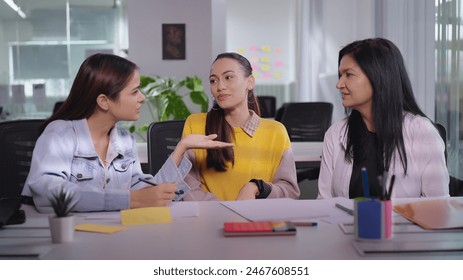 Indian smiling young adult woman business talking break time together indoor workplace. Teen age female corporate sitting office chair colleague speak group nodding listening gossip modern company  - Powered by Shutterstock