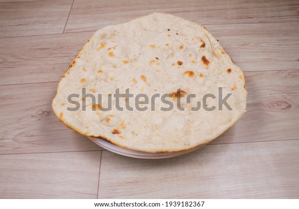 indian special flat bread\
also known as tandoori roti or naan, served in a white ceramic\
quarter plate