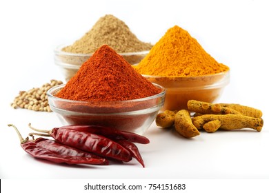 Indian Spices, Chilli powder , Coriander powder ,turmeric powder ,Chilli, Coriander seeds ,turmeric root 
in glass bowl - Shutterstock ID 754151683
