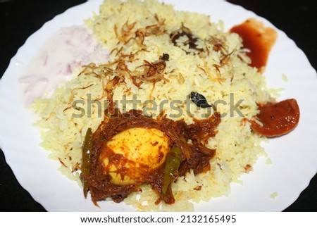 Indian spices, rice, either with meat, or eggs or vegetables such as potatoes, carrot. Biryani is one of the popular dishes in South Asia. chilly egg briyani with pickle.