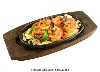 Indian starter meal tava tiger prawn grilled in tandoor and sizzling on wooden metal plate isolated from background