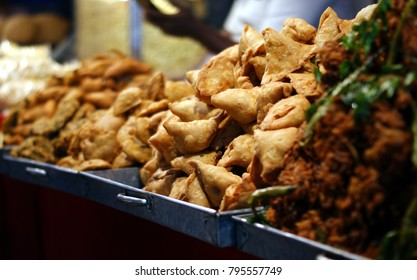 Indian Street Food Pakora, Samosa And Mirchi Bajji In Display In Front Of A Shop In A Busy Market Place