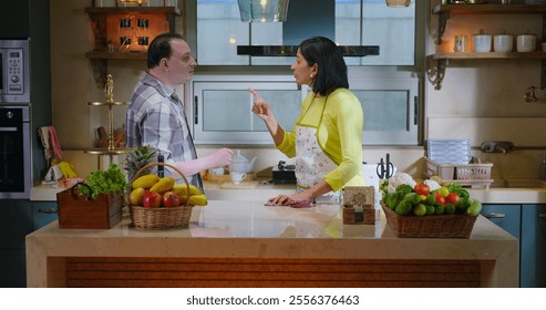 Indian stressed upset tense elder senior couple pair arguing fight shout feel bad hurt at modern house kitchen. Angry sad mature adult husband wife quarrel scream blaming on family problem indoor home - Powered by Shutterstock