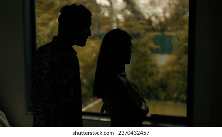 Indian stressed upset tense husband wife arguing fighting shouting on each other at dark indoor home. Silhouette angry sad boyfriend girlfriend quarreling screaming on family problems in evening house - Powered by Shutterstock