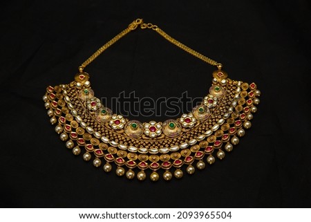 Indian style beautiful Neckless gold jewellery isolated on black background top view. Jewellery stock photo.