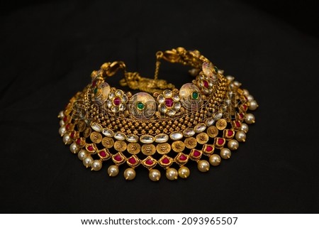 Indian style beautiful Neckless gold jewellery isolated on black background. Jewellery stock photo.