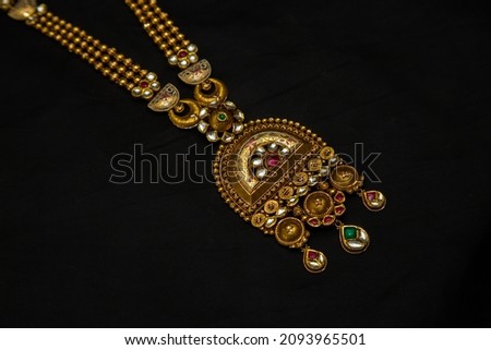 Indian style beautiful Neckless pendent gold jewellery isolated on black background. Jewellery stock photo.
