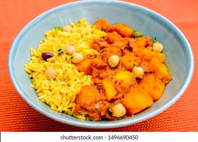 Indian Style Spicy Traditional Potato Vegetarian Curry With Yellow Pilau Rice and Chickpeas