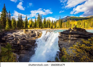 Indian summer in the Rocky Mountains, The magnificent powerful Athabasca Falls, popular with tourists. Canada. Travel and photo tourism concept
