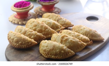 Indian Sweet item Popularly Known as Karanji or Gujiya is served on wooden platter. (Indian Food Concept) - Shutterstock ID 2183026749