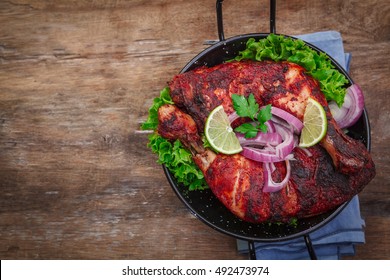 Indian tandoori leg chicken with spices and vegetables