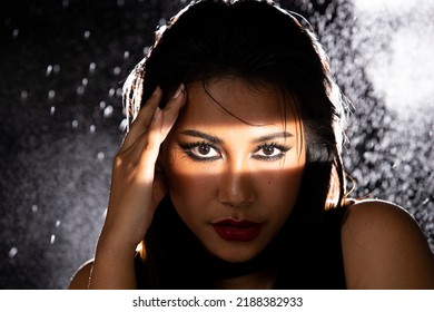 Indian Tanned Skin Asian Woman Show Face Make Up With Backlit Light And Water Splash Spray. Shadow Silhouette Female Head Express Feeling Dramatic Over Beautiful Elegance Black Background Copy Space