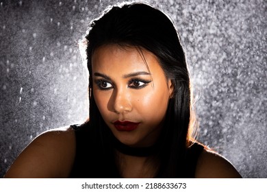 Indian Tanned Skin Asian Woman Show Face Make Up With Backlit Light And Water Splash Spray. Shadow Silhouette Female Head Express Feeling Dramatic Over Beautiful Elegance Black Background Copy Space