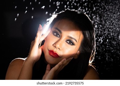 Indian Tanned Skin Asian Woman Show Face Make Up With Backlit Light And Water Splash Spray. Shadow Silhouette Female Head Express Feeling Dramatic Over Beautiful Elegance Black Background Copy Space