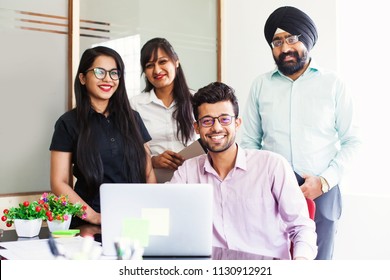 Indian Team Of Four People Posing In Office With Laptop