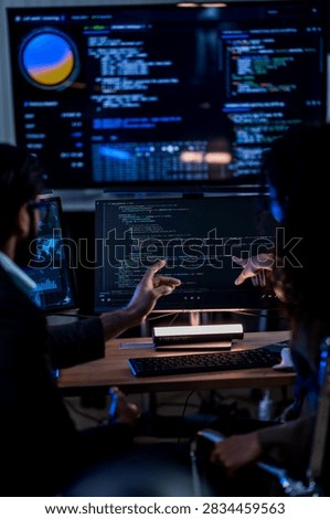 Indian technical lead explaining complex code structures and AI model inference parameters to a Brazilian colleague during a programming sprint.