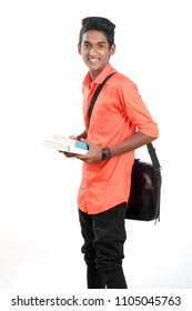 Indian Teen Boy Along With His Books And Laptop On White Background