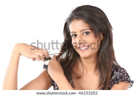 Indian teenage girl cutting her hair with scissor
