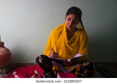 Indian Teenager Girl Student Doing Her School Homework Writing Notebook At Home