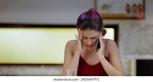 Indian thirsty tired sad depressed gen z woman standing in modern kitchen at indoor home. Exhausted upset tense worried young female feel bad hold mobile talking distant phone call inside house - Powered by Shutterstock