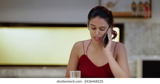 Indian thirsty tired sad depressed woman standing in modern kitchen at indoor home. Exhausted upset tense worried emotional young female feel bad hold mobile distant talking on phone call inside house - Powered by Shutterstock