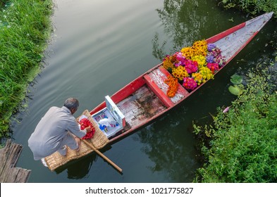Indian trader in floating vegetable and floral market in the middle of Dal Lake in Srinagar, Kashmir, India.