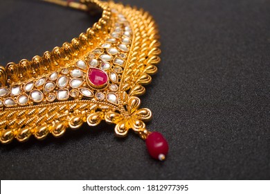 Indian traditional gold necklace on black texture background. selective focus. 