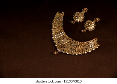 Indian Traditional Jewellery. Necklace with an earring on brown background.