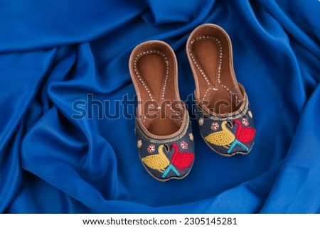 Indian Traditional jutti, traditional footwear of North India isolated on Blue background 