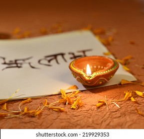 Indian Traditional Lamp Placed On A Book With Sanskrit Calligraphy