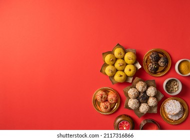 Indian traditional sweets various laddu for festival on red background with copy space, flat lay - Shutterstock ID 2117316866
