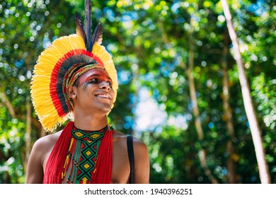 Indian from the Pataxó tribe with feather headdress looking to the right. Indigenous from Brazil with traditional facial paintings.
