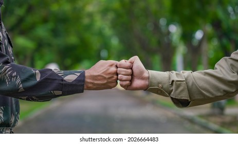 Indian in uniform bumps fists with a police officer.  - Powered by Shutterstock