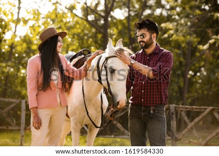 Indian urban Couple with Horse in Farm House Preparing For the Horse Ride . 