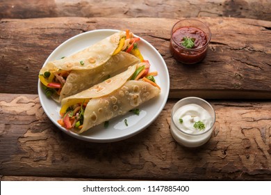 Indian Veg chapati Wrap / Kathi Roll, served in a plate with sauce over moody background. selective focus